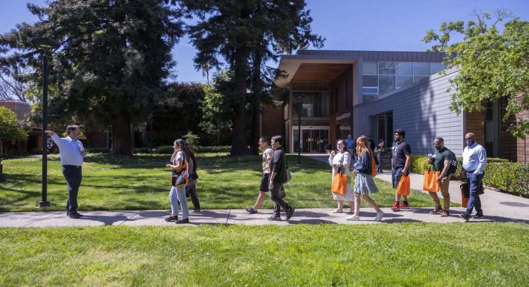 A group of students walk across campus